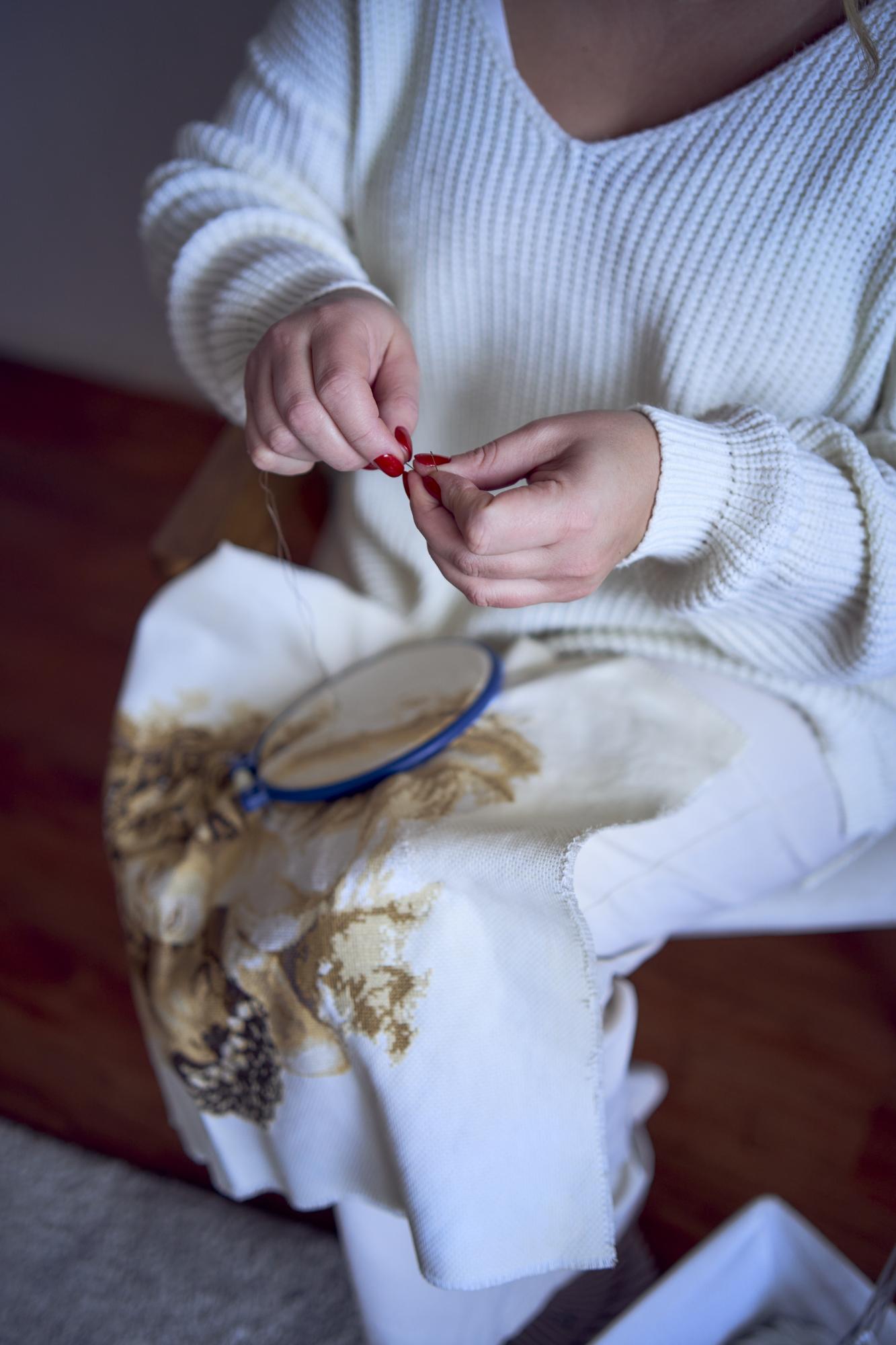 Artist hands embroidering a silk textile